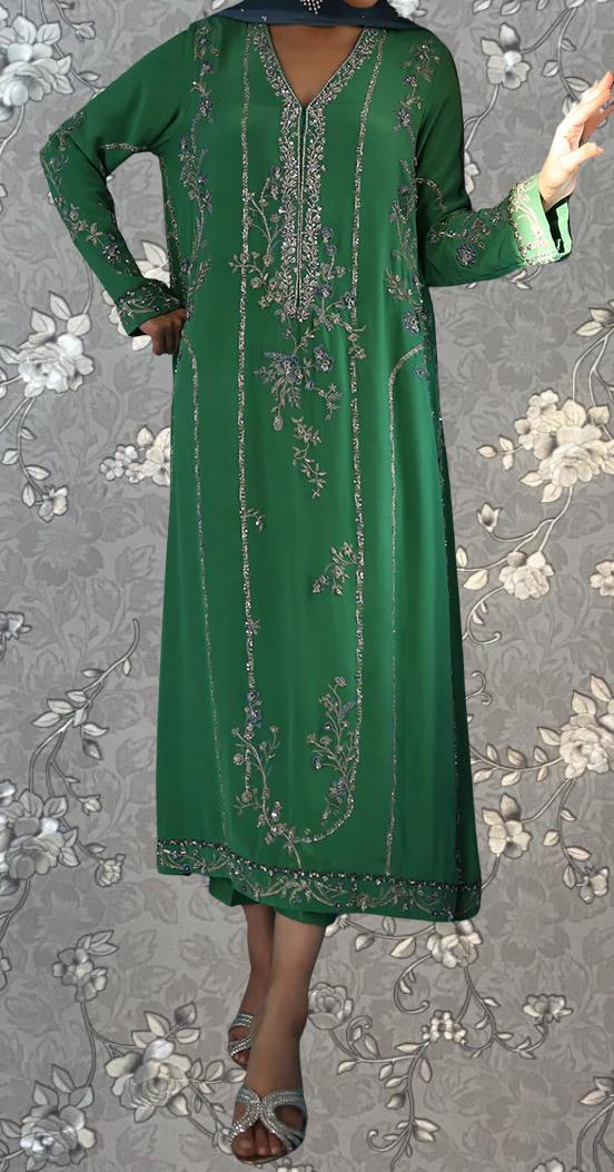 A person wearing a long, green dress with intricate embroidery and floral patterns.