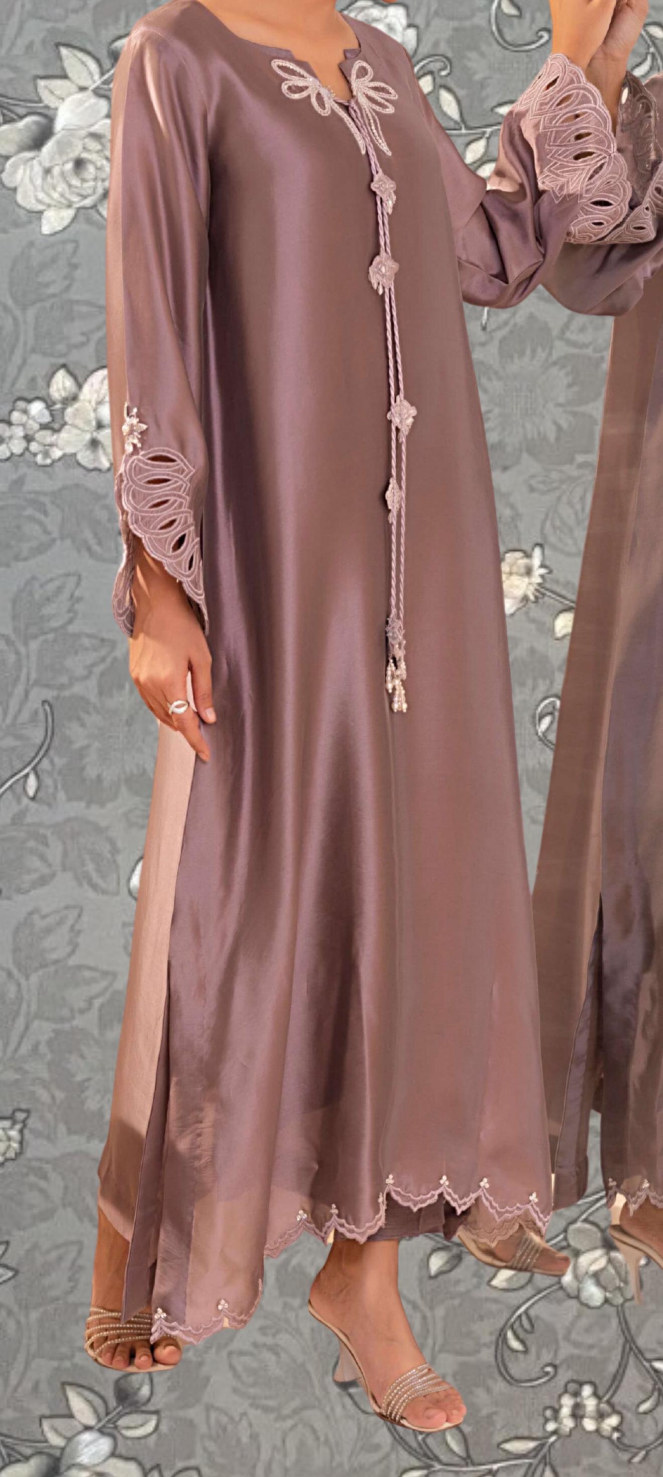 A woman wearing a long, flowing purple dress with lace sleeves and a scalloped hem.