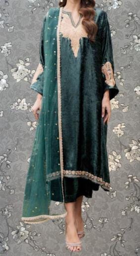 A woman wearing a green velvet dress with gold accents and a matching green shawl.