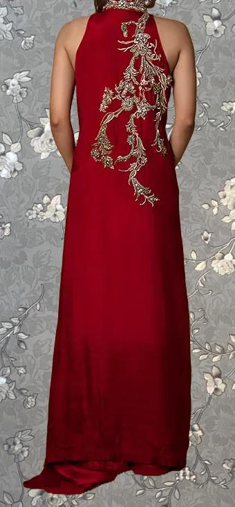 a woman wearing a long, red dress with intricate embroidery on the back.
