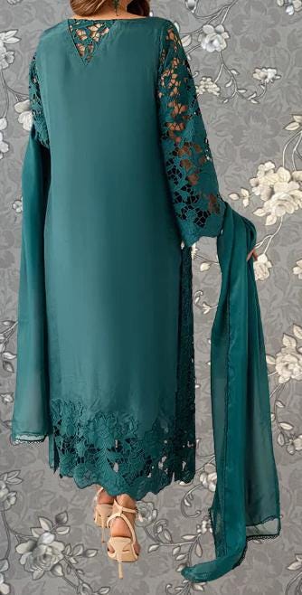 A woman wearing a long, green dress with lace detailing and a matching green shawl draped over her shoulders.