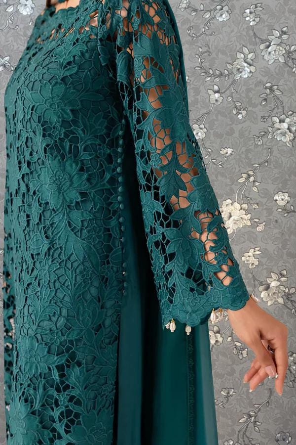 A close-up view of a person wearing a green lace dress with intricate patterns and designs.