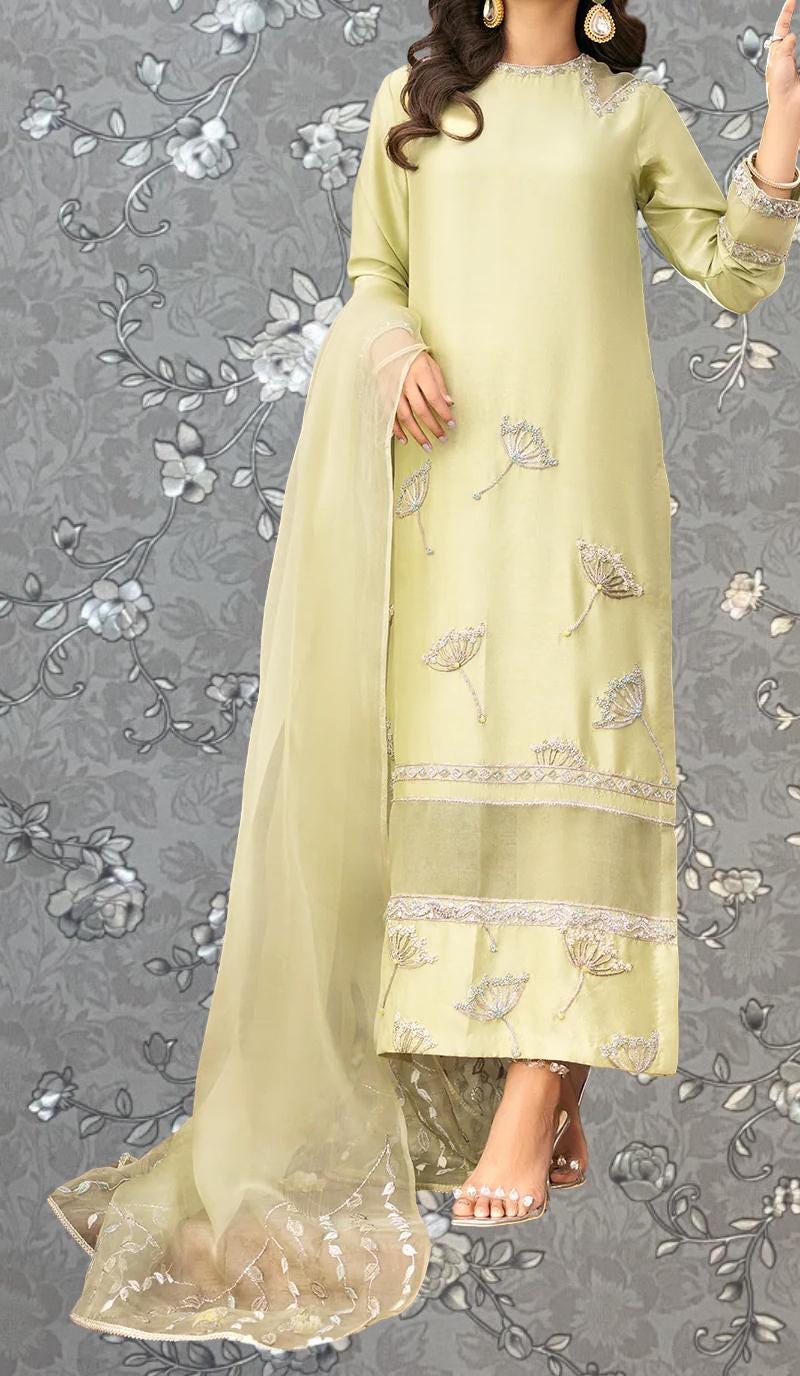 A woman wearing a long, yellow dress with intricate embroidery and a matching shawl.