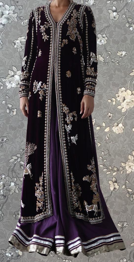 A woman wearing a long, purple and gold embroidered dress with a high collar and long sleeves.