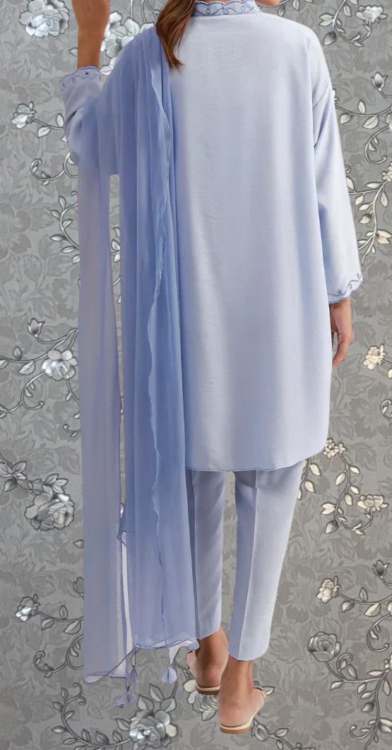 a person wearing a light blue outfit, including a long shawl draped over the shoulder and matching light blue pants.