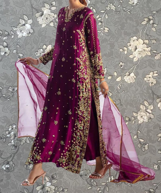A woman wearing a long, purple dress with gold embroidery and a matching pink shawl is shown against a gray floral background.