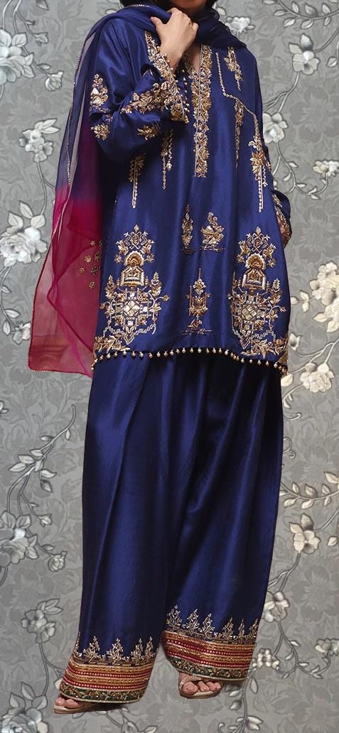 A person wearing a blue and gold traditional outfit with intricate embroidery and patterns.