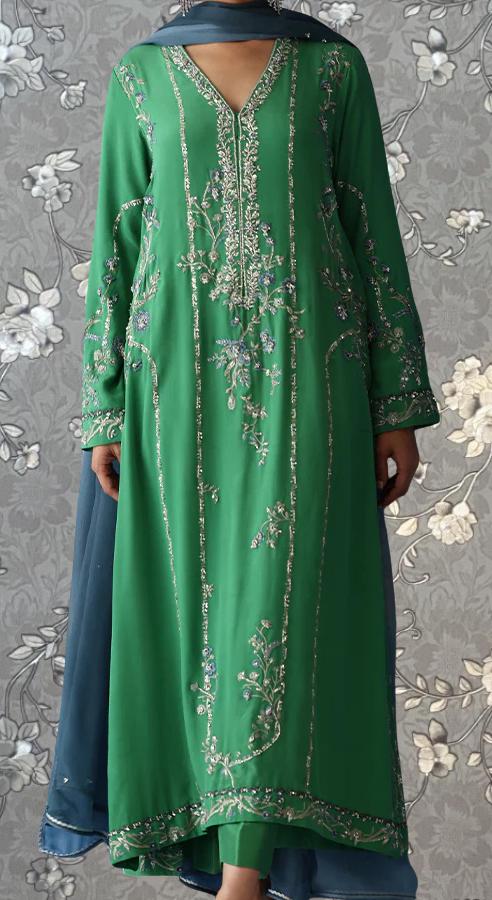 A woman wearing a long, green dress with intricate embroidery and floral patterns.